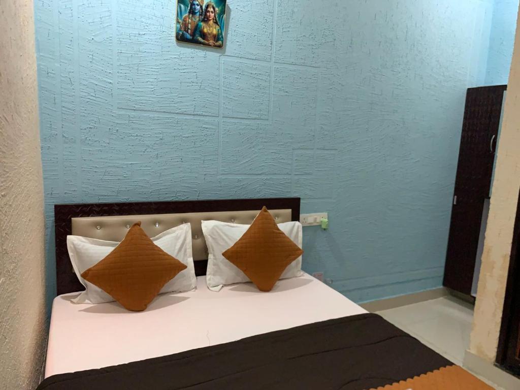a bedroom with a bed with brown and white pillows at SRT Homes Ranchi in Rānchī