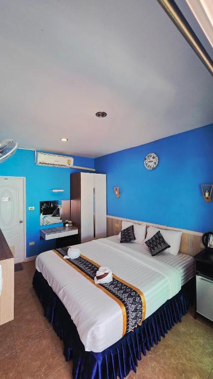 a bedroom with a large bed with a blue wall at Searide hotel in Ao Phutsa