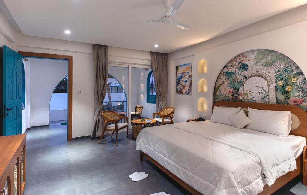 a bedroom with a large bed with a large painting on the wall at Larissa Resort in Nashik