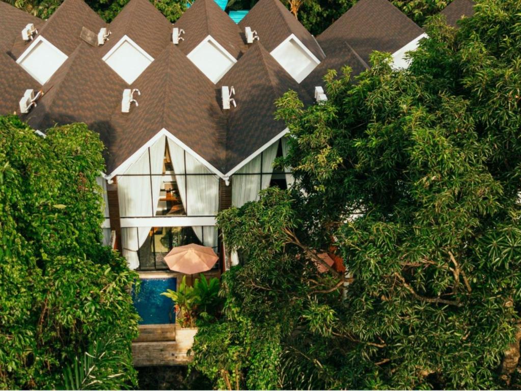a large house with a roof with an umbrella at Moon Rock Villas Ubud by Ribas in Gianyar