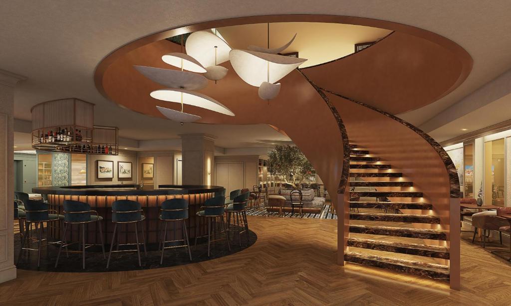 a lobby with a spiral staircase and a bar at Tivoli Coimbra Hotel in Coimbra