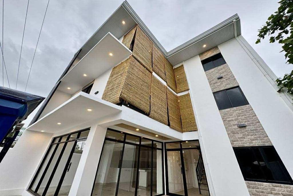 a large brick building with glass windows at Eva's Guest House in General Luna