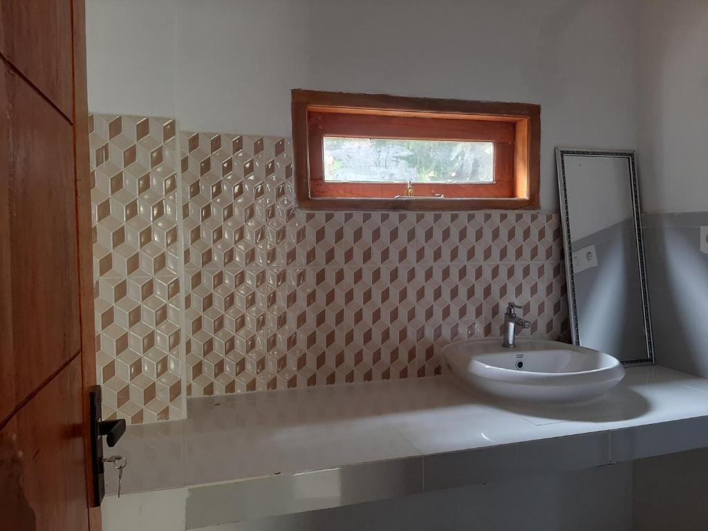 a bathroom with a sink and a mirror at Guesthouse sirkuit mandalika in Sengkol
