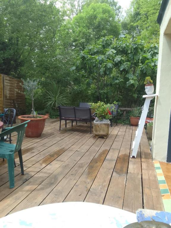 a wooden deck with a bench and some plants at atypical house garden in Saint-Paulet-de-Caisson