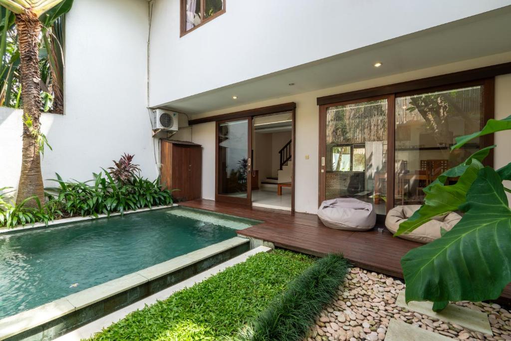 a swimming pool in front of a house at Du Ciel Villa by Betterplace in Canggu