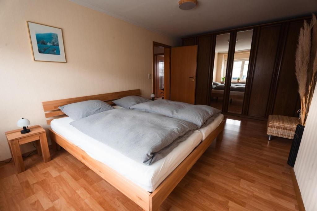 a large bed in a room with a wooden floor at Ferienwohnung Haus Mäsch in Wellen