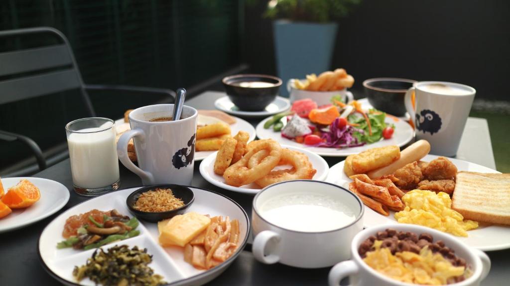 A plated breakfast spread with hot food, fruit, salad and drinks.