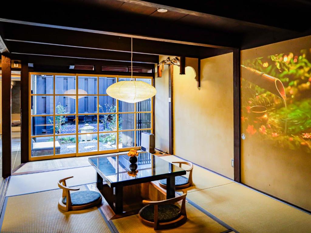 a room with a table and chairs and a window at 椿とことは in Obama