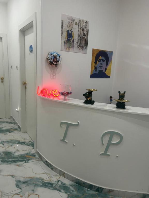 ein weißes Zimmer mit einem Regal voller Gemälde und Bilder in der Unterkunft Tp luxury in Neapel