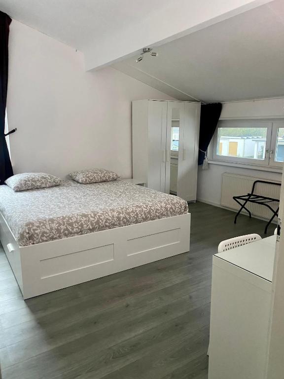 a white bedroom with a bed in a room at De Keizersmantel in Son