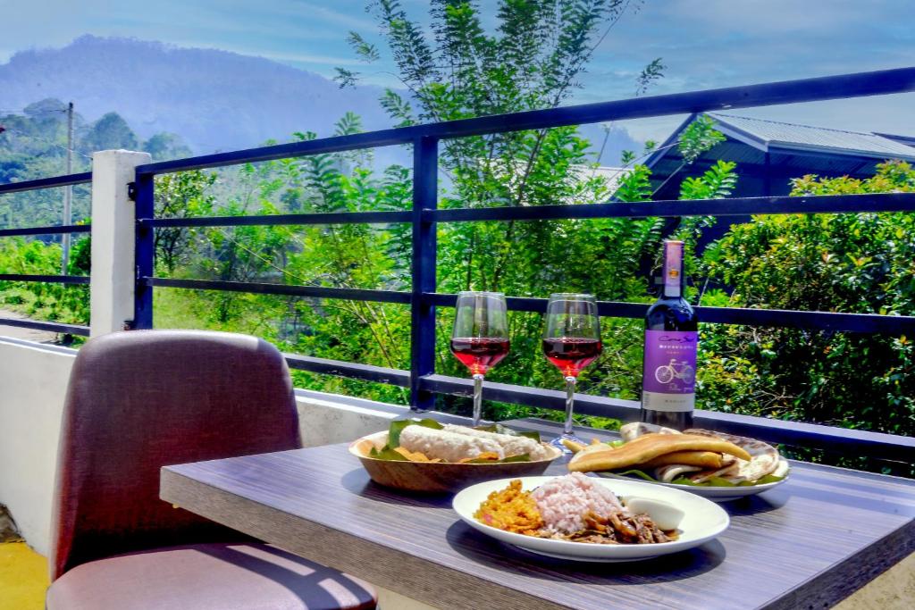 a table with two glasses of wine and food at Greenland Villa Ella in Ella