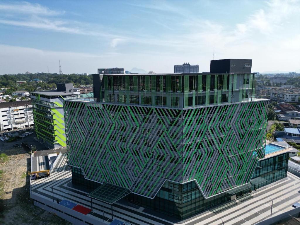 a building with a green facade on top of a city at 56 Hotel Block B in Kuching