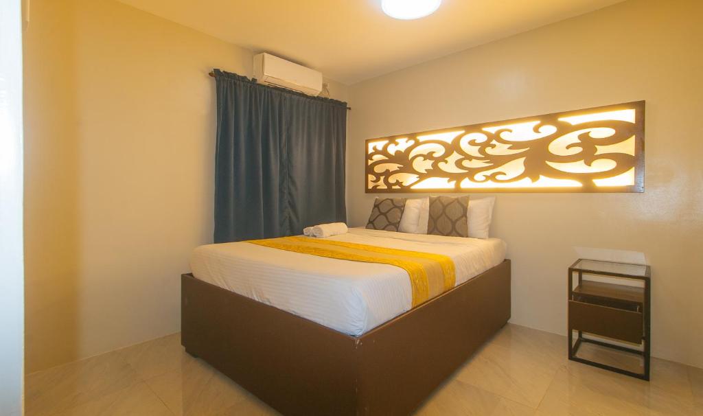 a bedroom with a bed with a large headboard at Algers Suites Bayan-Bayanan Marikina City in Manila