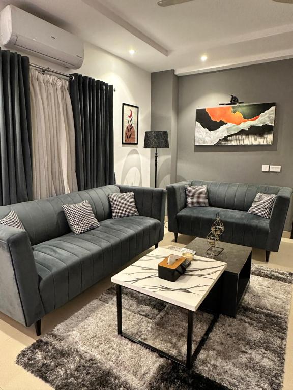 a living room with a couch and a table at Staye Deluxe 2BHK in Islamabad