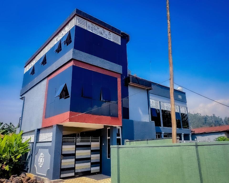 a building that is painted blue and red at Kigombe River Motel- musanze in Ruhengeri