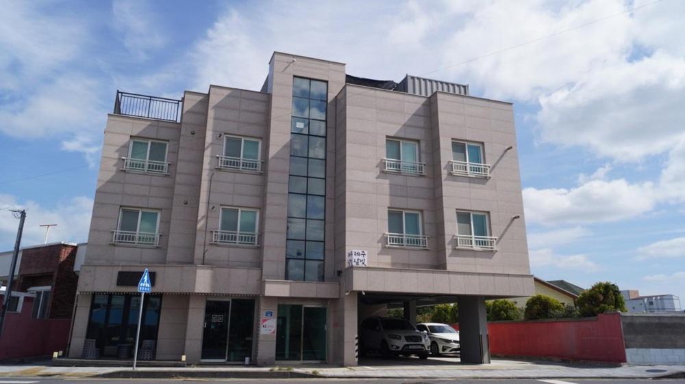 a building with a car parked in front of it at Jeju Dalbit Pension in Jeju