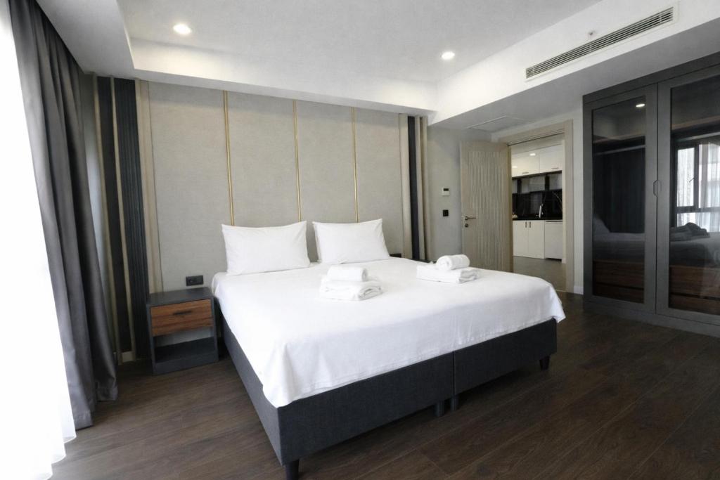 a bedroom with a large white bed with white pillows at Hilloria Residence Hotel in Serdivan