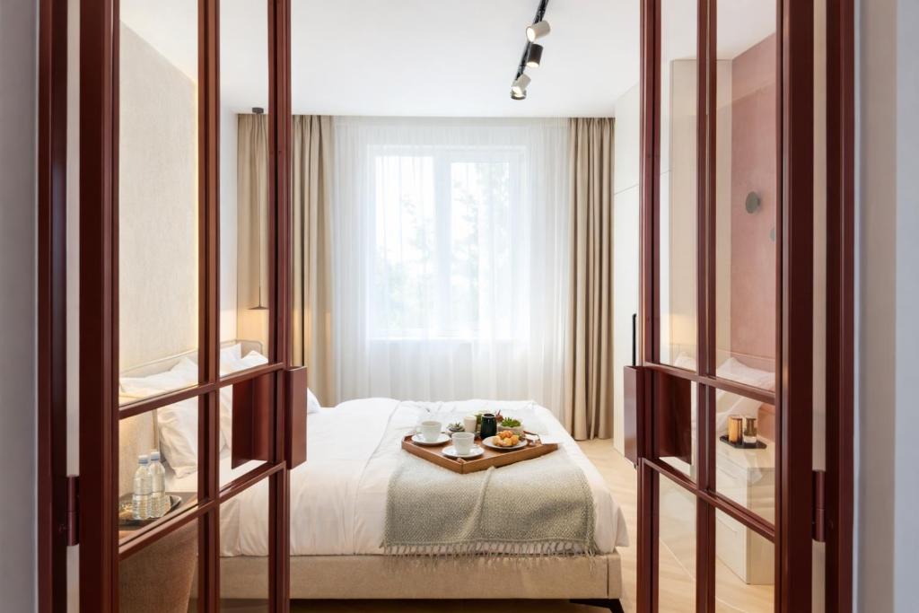 a hotel room with a bed with a tray of food on it at Premium Art Deco Loft in Iaşi