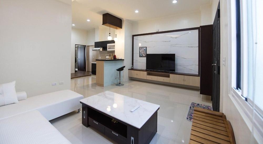 a living room with a couch and a large screen television at Happiness B&B in Linbian