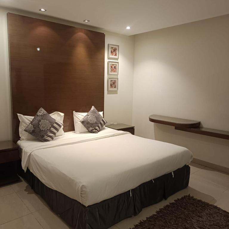 a bedroom with a large white bed with pillows at شقق ذرا الماضي المخدومه2 in Al Bukayriyah