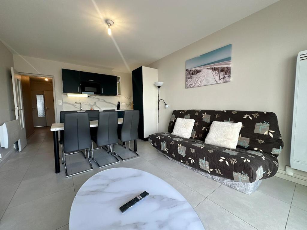 a living room with a couch and a table at T3 Rénové vue mer in Saint-Jean-de-Monts