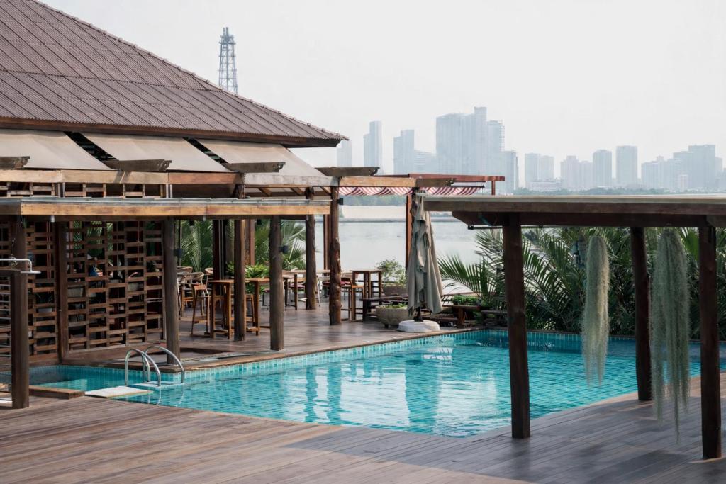 a pool at a hotel with a view of the city at Baan Krai Nao The Riverfront in Bangkok
