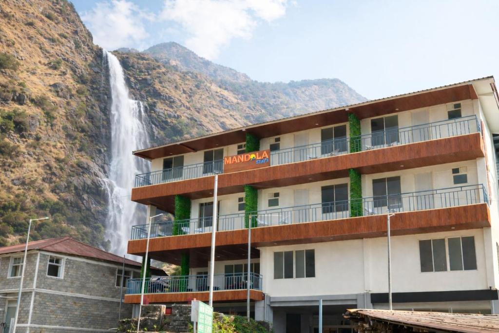 a hotel with a waterfall in the background at Mandola Stays in Girgaon