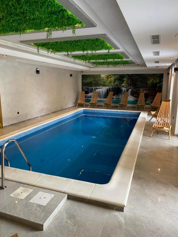 a large swimming pool with chairs and a swimming pool at Apartman Tornik Relax&Spa 3 in Zlatibor