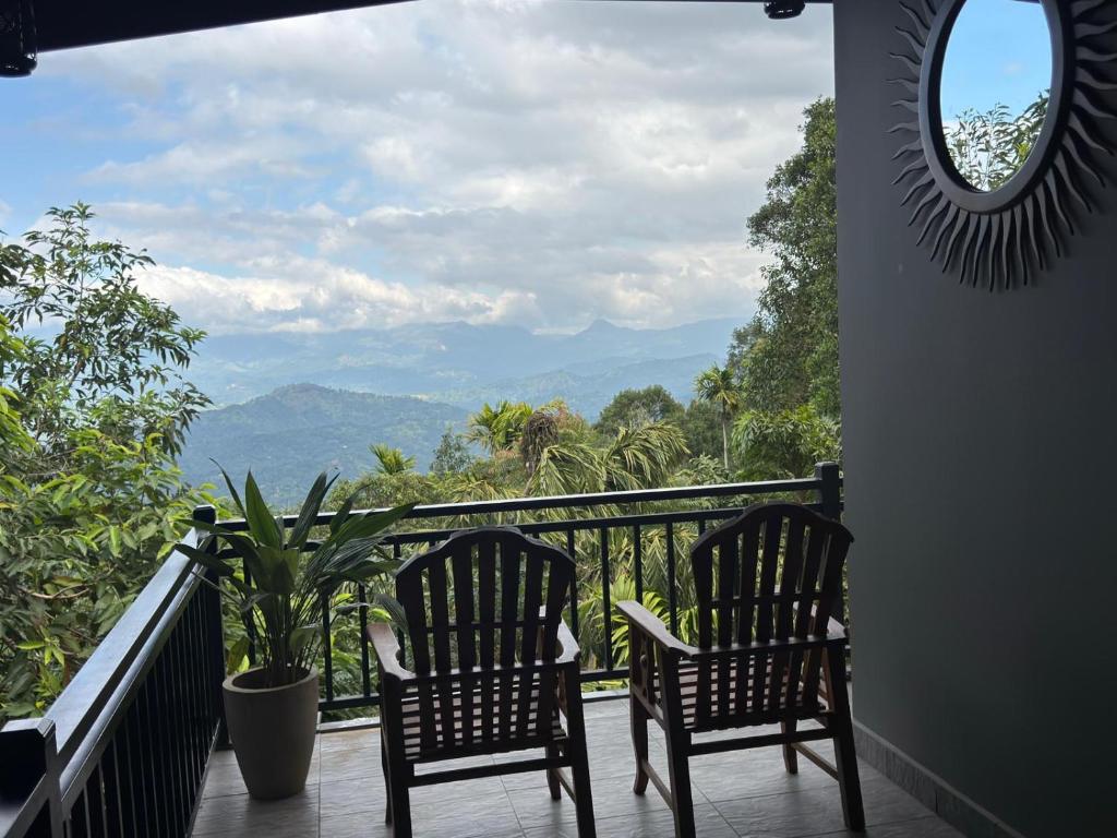 two chairs on a balcony with a view of mountains at Sunrise Villa in Kandy