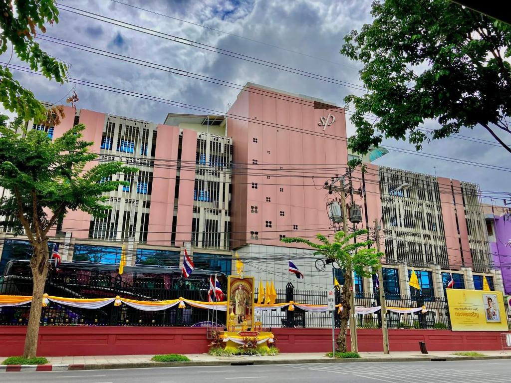 a pink building with flags in front of it at โรงแรมสวนดุสิต เพลส in Ban Nong Chaeng