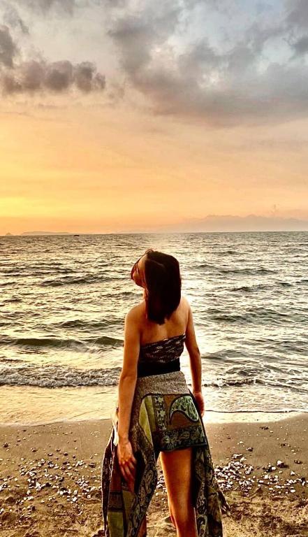 a woman standing on the beach near the ocean at Shigemary Kubohouse in Capepisa