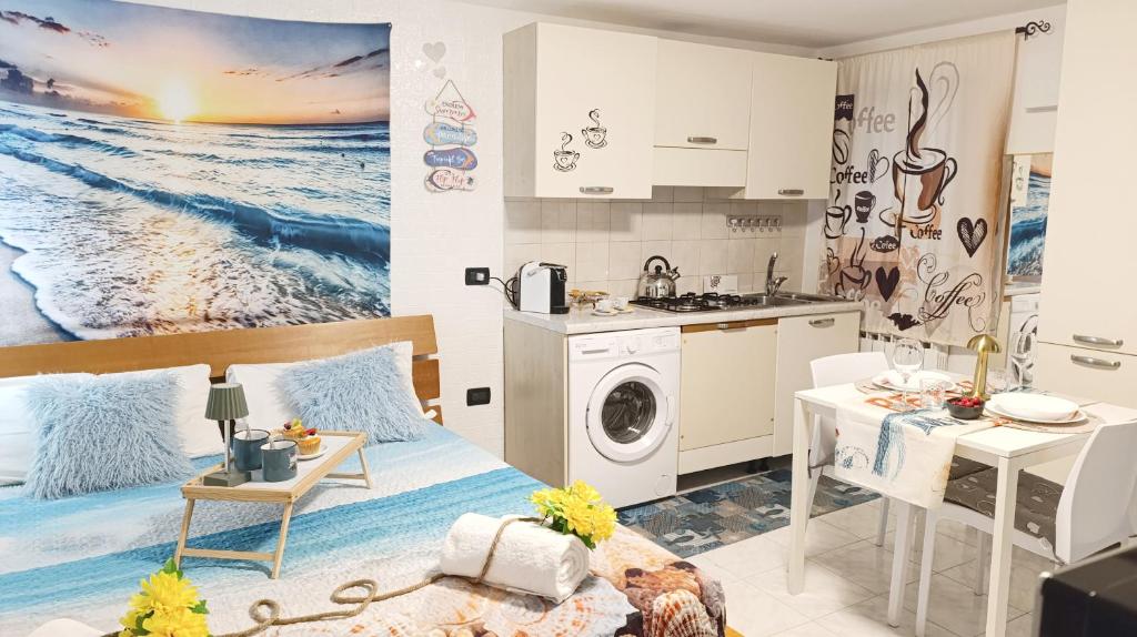 a kitchen and living room with a bed and a table at Alicetta Apartment by Ca-Sa Check in Chioggia
