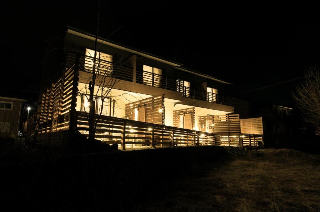 a house lit up at night with lights on it at SORAPIA Villa Mt.FUJI Front in Fujikawaguchiko