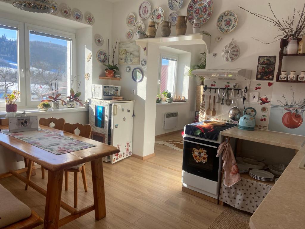 a kitchen with a table and a stove top oven at Luxusný apartmán u Loly in Polomka