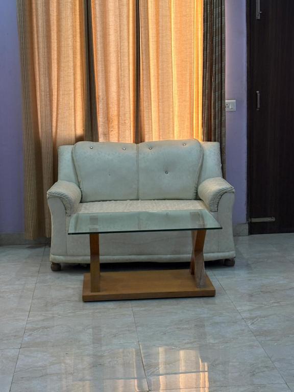 a couch sitting in front of a window at Hotel Shyam Regency in Sabāthu