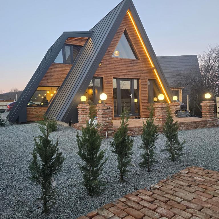 ein Haus mit Bäumen davor in der Unterkunft FreeDom Chalet in Verneşti