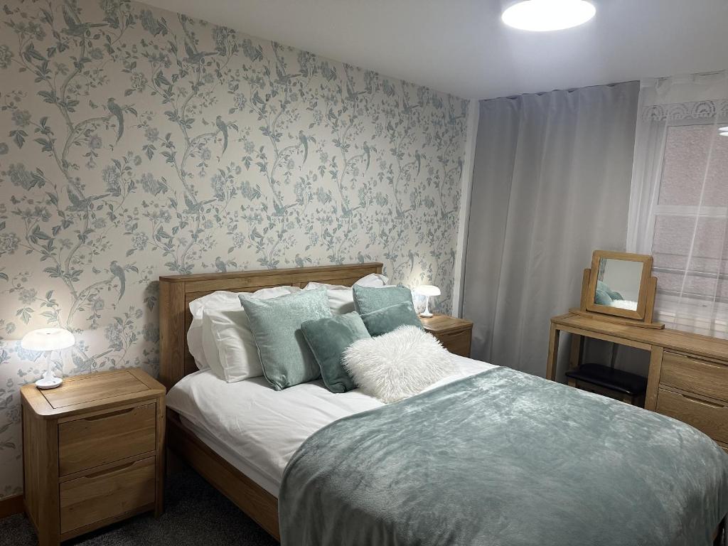 a bedroom with a bed with blue floral wallpaper at LaScala Apartment in Inverness