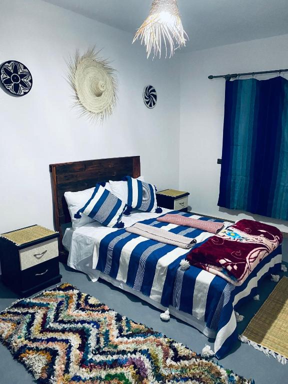 a bedroom with a bed and a rug on the floor at calm stay ouassane in Essaouira