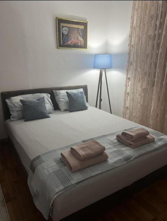 a bedroom with a bed with two towels on it at emem in Kuršumlija