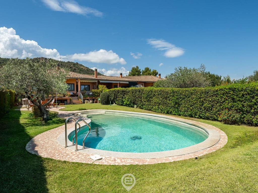 a swimming pool in the yard of a house at Estay - Carrubo Oasis - Swimming pool & Garden in Pula