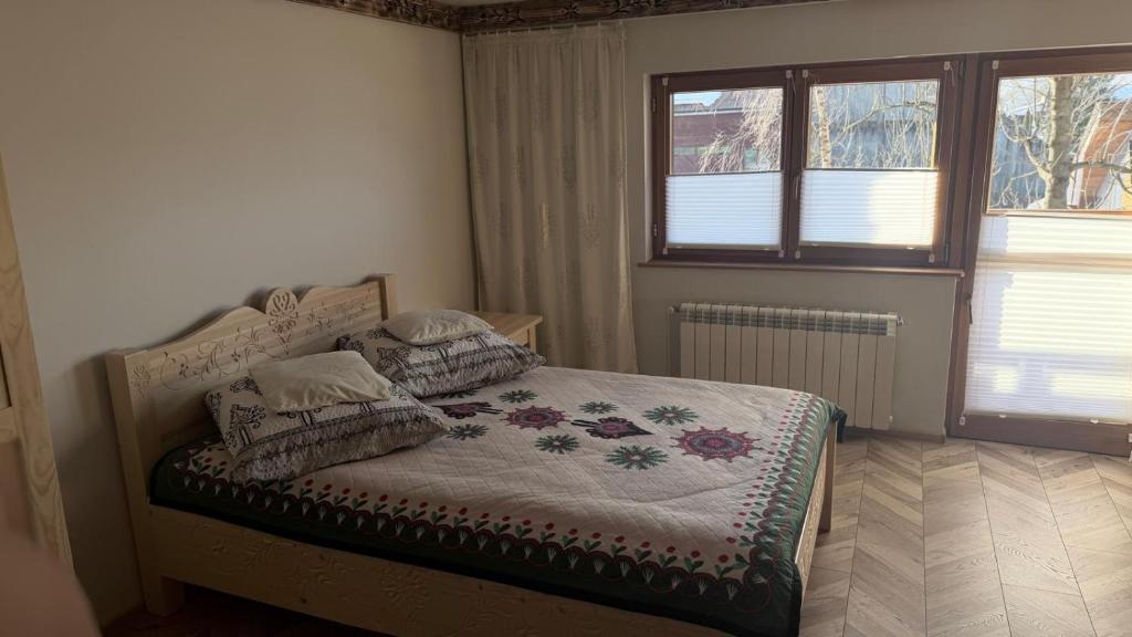 a bedroom with a bed with pillows on it at Apartament u Bafiów in Chochołów