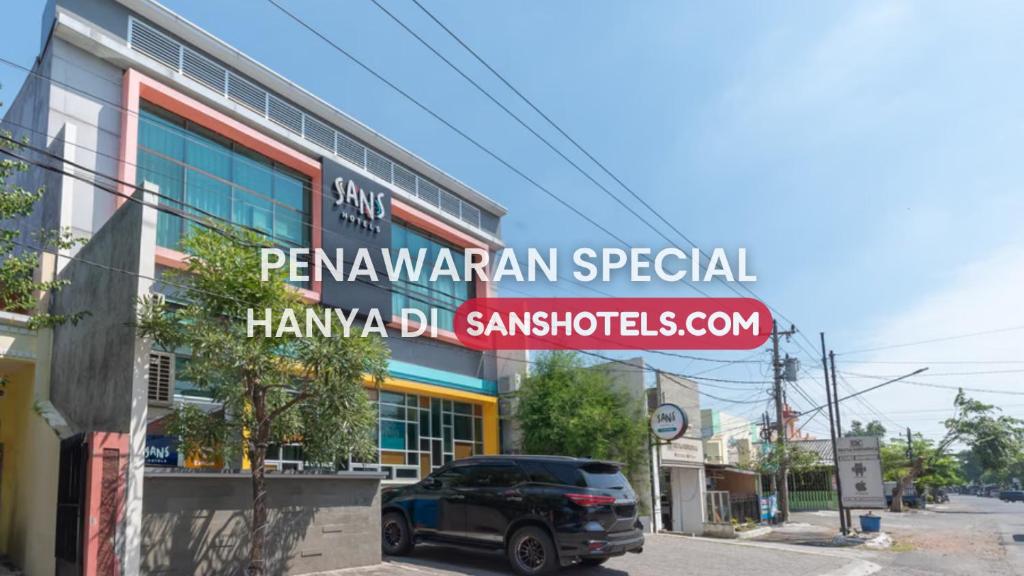 a car parked in front of a building at Sans Hotel Good Wish Semarang in Jomblang