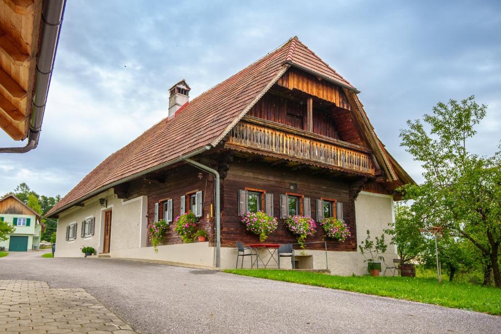 a wooden house with flowers on the side of it at Winzerhaus am Eichberg in Leutschach
