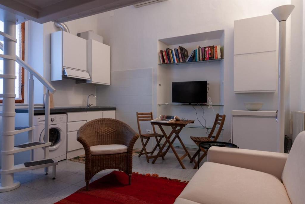 a kitchen and living room with a table and chairs at Appartamento MO in Follonica
