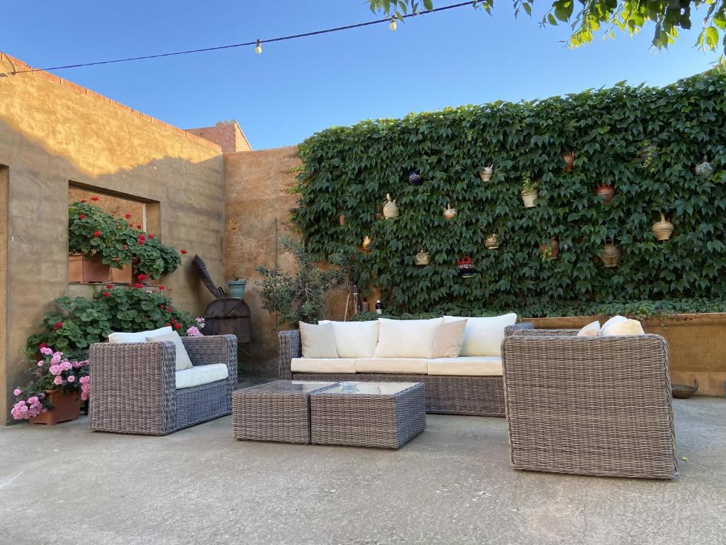 a couch and chairs in front of a hedge at Can Genis Turismo Rural in Peralada