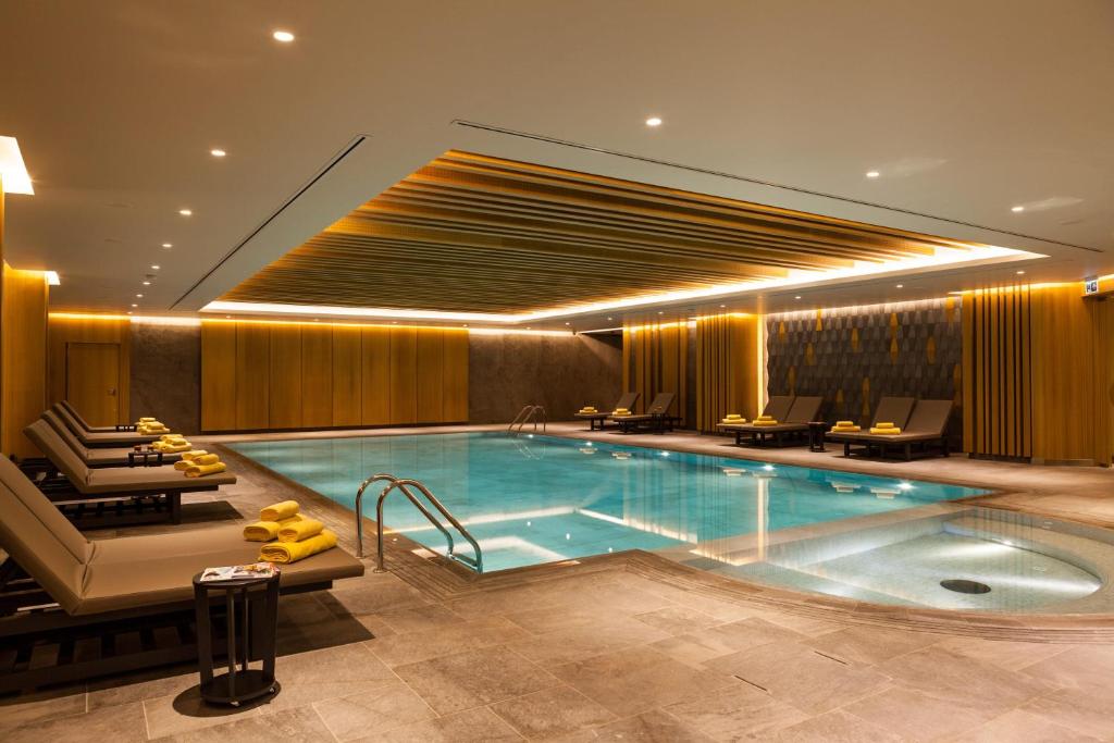 a swimming pool in a hotel with chairs and a table at Wish More Hotel Istanbul in Istanbul
