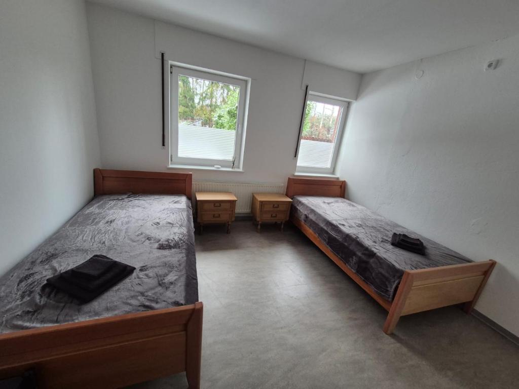 a bedroom with two beds and two windows at Brull in Lengerich