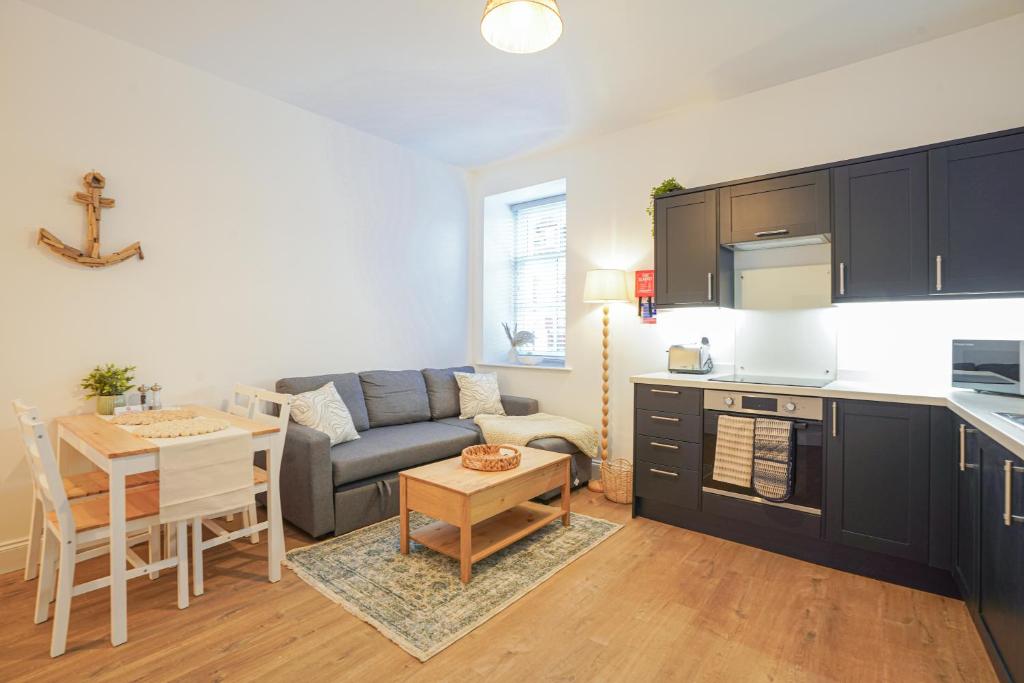a kitchen and living room with a couch and a table at Apt 1 Armatage Flats, Eyemouth in Eyemouth