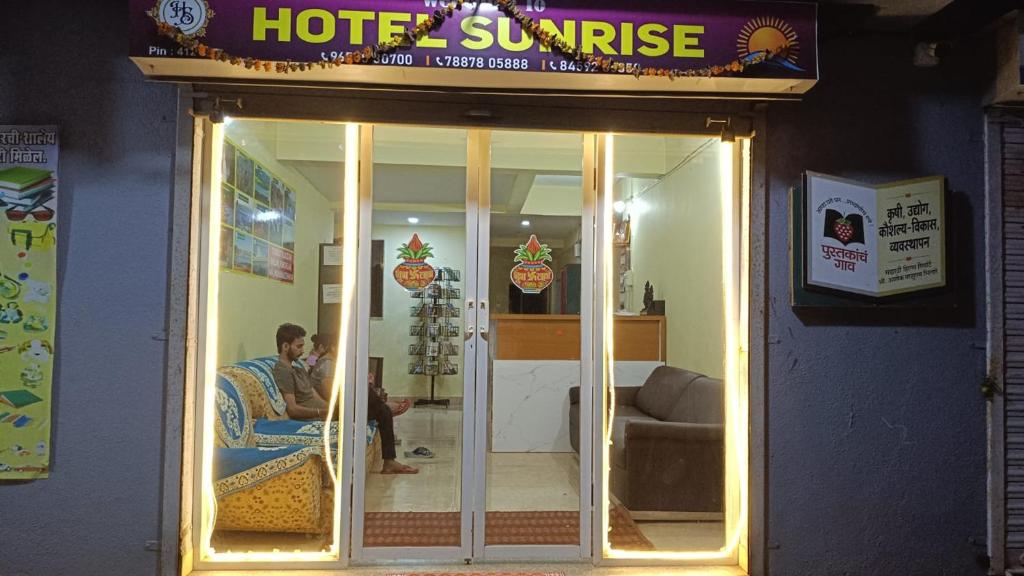 a man sitting in a chair in front of a hotel sunset at Hotel Sunrise, Panchgani in Panchgani