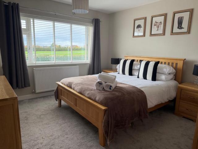a bedroom with a bed with two towels on it at Modern homely well equipped 2BR bungalow next to the racecourse free parking in Hereford